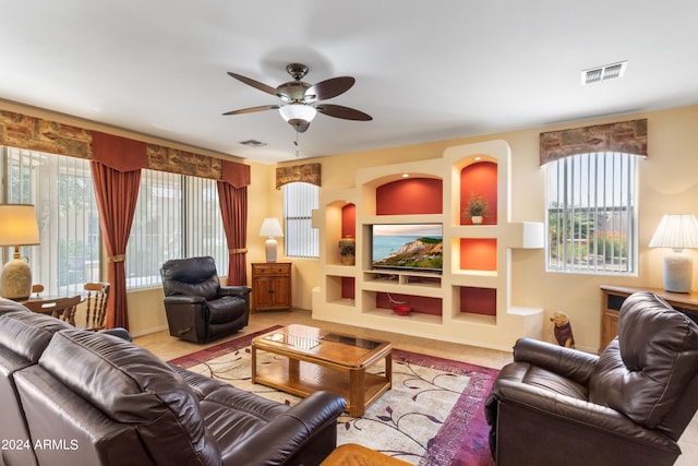 living room with ceiling fan and built in shelves