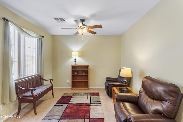 sitting room with ceiling fan and light carpet