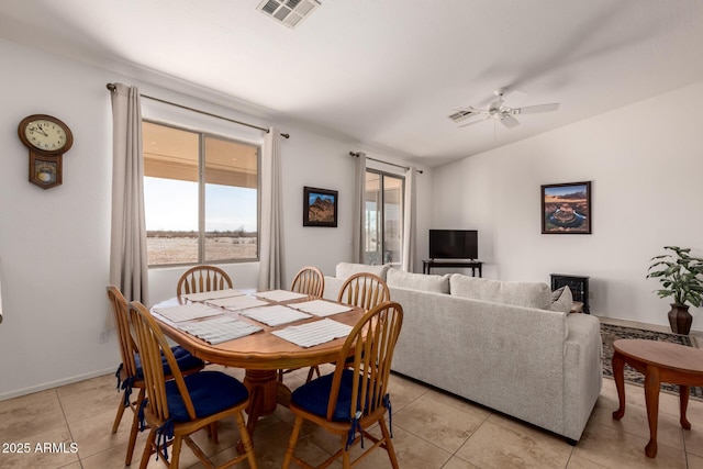 dining space featuring a ceiling fan, visible vents, vaulted ceiling, and light tile patterned floors