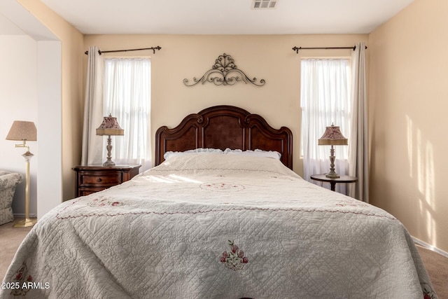 carpeted bedroom with visible vents and baseboards