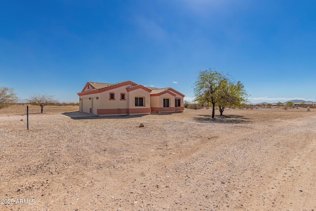 rear view of property featuring stucco siding and a tiled roof