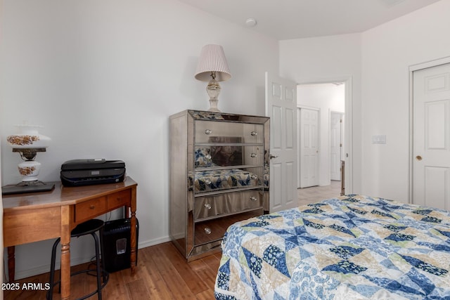 bedroom featuring wood finished floors and baseboards