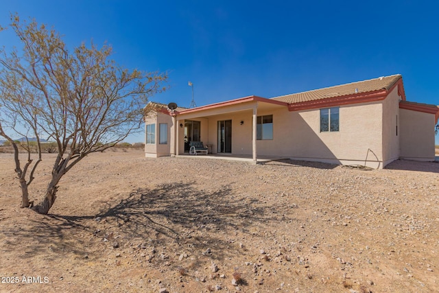 back of property with a patio area, a tiled roof, and stucco siding