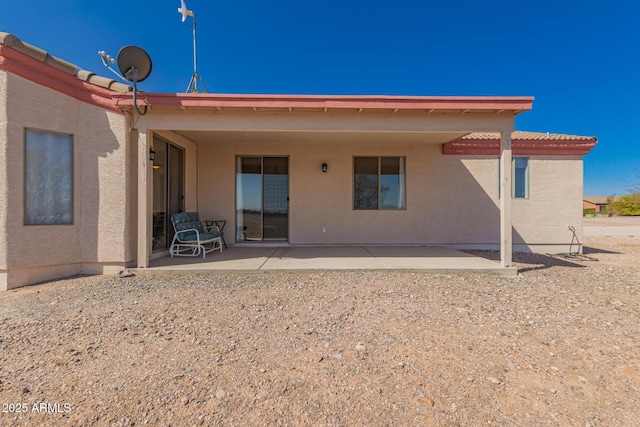 back of property featuring a patio, a tiled roof, and stucco siding