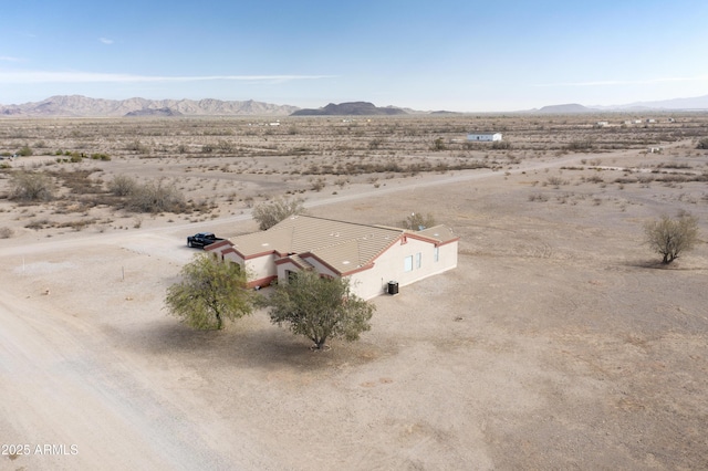 drone / aerial view featuring a desert view and a mountain view