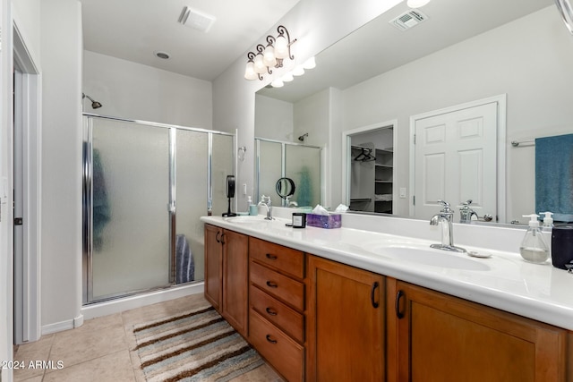 bathroom featuring tile patterned flooring, vanity, and walk in shower