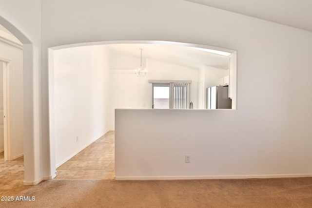 19002 N Toledo Ave, Maricopa, AZ 85138 - unfurnished room featuring light colored carpet, arched walkways, a notable chandelier, and baseboards