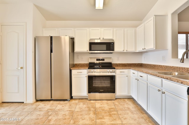 19002 N Toledo Ave, Maricopa, AZ 85138 - kitchen with lofted ceiling, appliances with stainless steel finishes, a sink, and white cabinetry