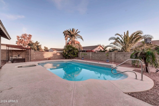 pool at dusk featuring a patio