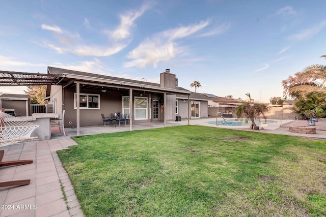 back of house featuring a lawn, a pergola, and a patio area