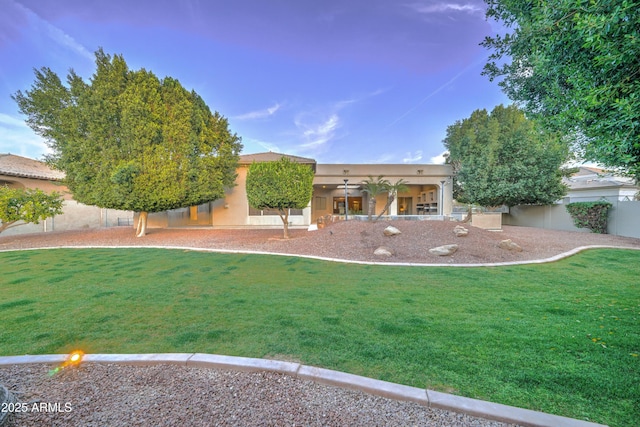 view of front of home with a front yard and ceiling fan