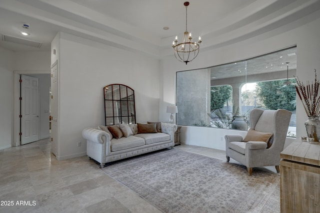 living room with a tray ceiling and a chandelier