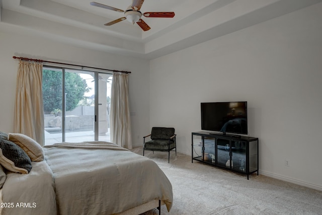 carpeted bedroom with a raised ceiling, access to exterior, and ceiling fan