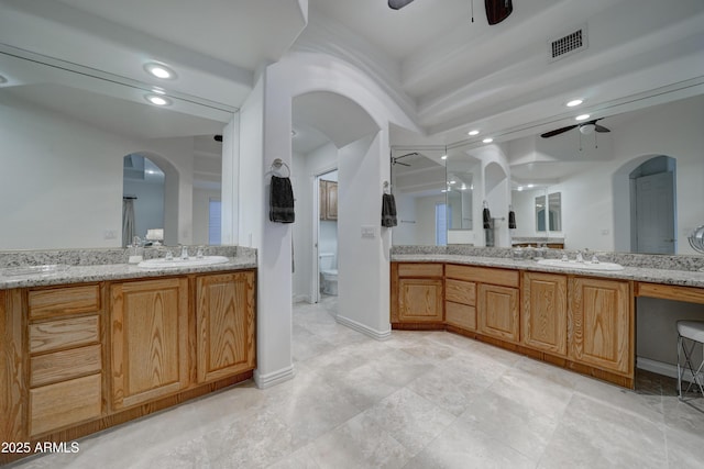 bathroom with vanity, toilet, and ceiling fan