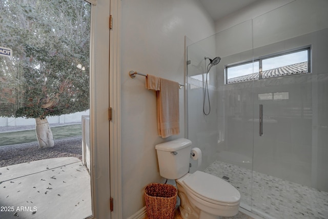 bathroom featuring toilet and a shower with shower door