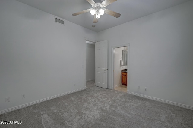 unfurnished bedroom featuring ensuite bath, light colored carpet, and ceiling fan