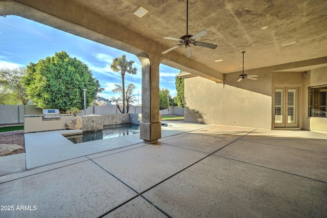 view of patio / terrace featuring a fenced in pool, ceiling fan, and exterior kitchen