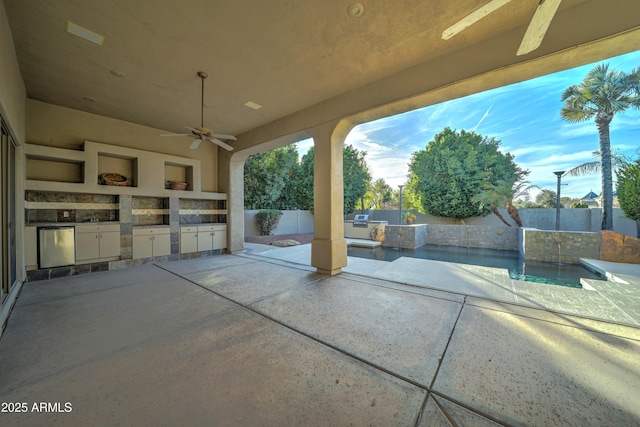 view of patio / terrace featuring a fenced in pool, ceiling fan, and an outdoor kitchen