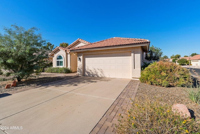 mediterranean / spanish-style house with a garage