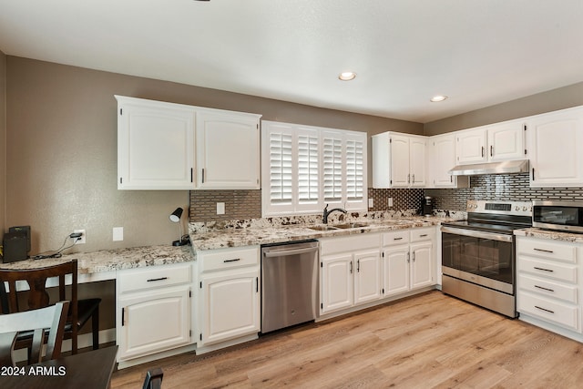 kitchen featuring white cabinets, sink, light wood-type flooring, and appliances with stainless steel finishes