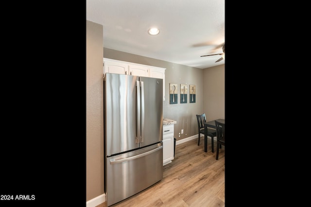 kitchen with ceiling fan, stainless steel refrigerator, white cabinetry, and light hardwood / wood-style flooring