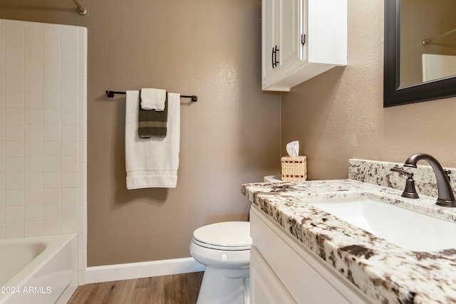 full bathroom with bathing tub / shower combination, vanity, hardwood / wood-style flooring, and toilet