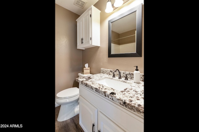 bathroom with toilet, vanity, and hardwood / wood-style flooring