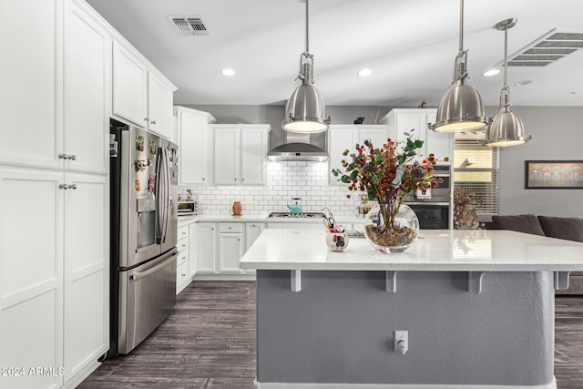 kitchen with white cabinetry, hanging light fixtures, stainless steel appliances, and a kitchen island