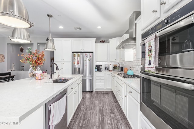 kitchen featuring sink, white cabinets, a kitchen island with sink, stainless steel appliances, and wall chimney exhaust hood