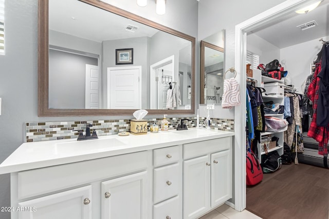 bathroom with hardwood / wood-style flooring, vanity, and decorative backsplash