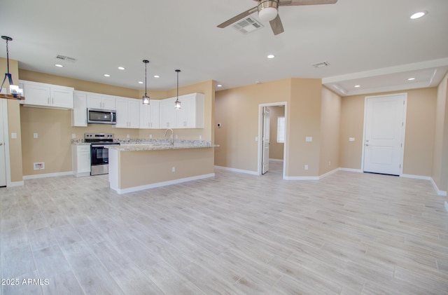 kitchen with appliances with stainless steel finishes, hanging light fixtures, light stone counters, white cabinets, and light wood-type flooring