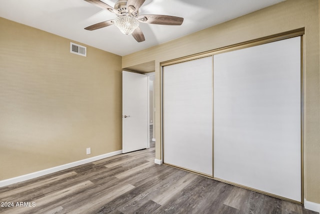 unfurnished bedroom featuring ceiling fan, a closet, and hardwood / wood-style floors