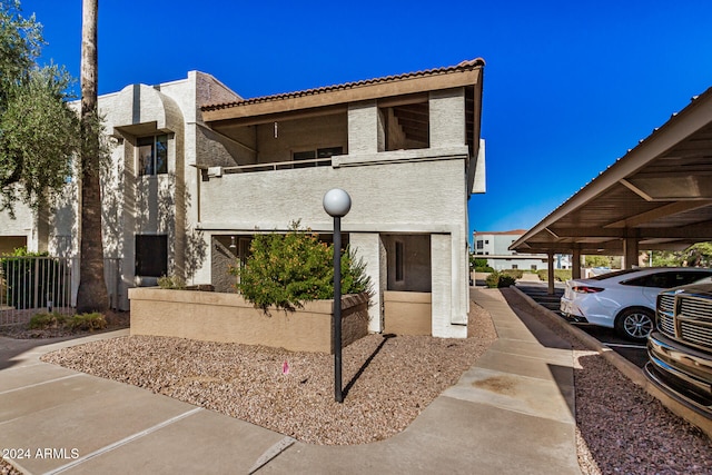 view of front of home featuring a carport and a balcony