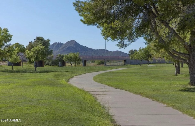 surrounding community with a mountain view and a yard