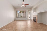 16813 S 30th Ave, Phoenix, AZ 85045 - unfurnished living room with ceiling fan, a fireplace, baseboards, and tile patterned floors