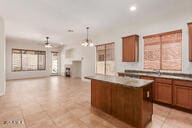16813 S 30th Ave, Phoenix, AZ 85045 - kitchen featuring a center island, brown cabinetry, open floor plan, hanging light fixtures, and recessed lighting