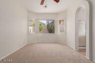 16813 S 30th Ave, Phoenix, AZ 85045 - spare room featuring arched walkways, ceiling fan, baseboards, and carpet
