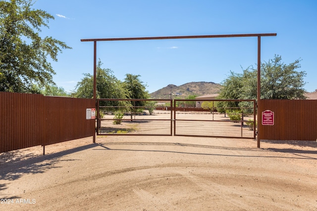 view of gate with a mountain view and fence