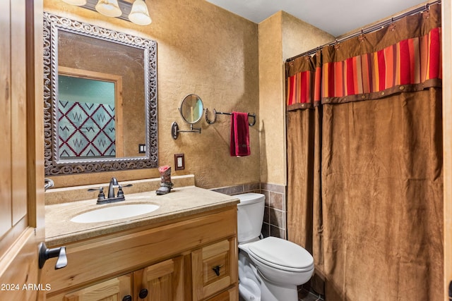 bathroom featuring vanity, toilet, tile walls, and curtained shower