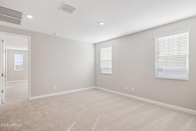 unfurnished room featuring light carpet, baseboards, and visible vents