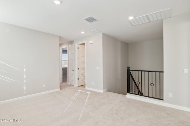 carpeted spare room featuring recessed lighting, visible vents, and baseboards