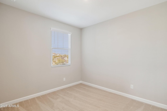 unfurnished room with baseboards and light colored carpet