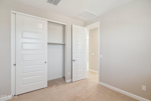 unfurnished bedroom featuring baseboards, a closet, visible vents, and carpet flooring