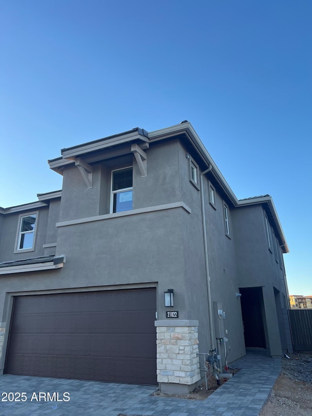 view of property exterior featuring a garage, fence, and stucco siding