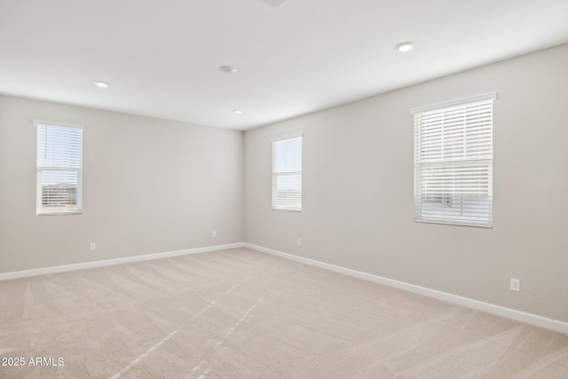 empty room with light carpet, recessed lighting, and baseboards