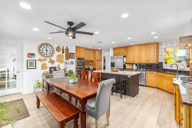 dining area featuring light wood-style floors, a ceiling fan, and recessed lighting