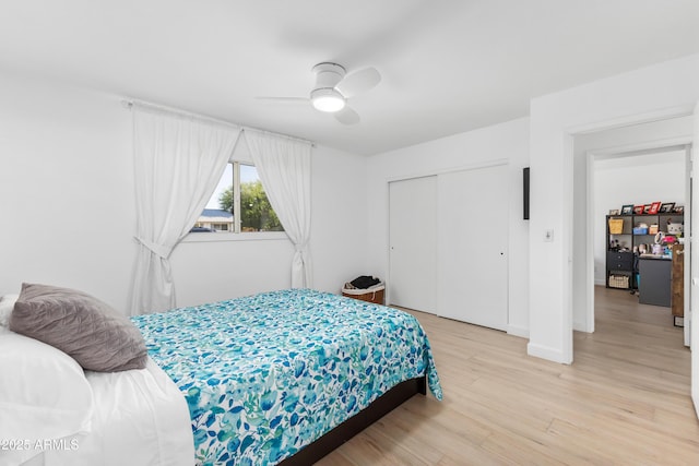 bedroom with baseboards, ceiling fan, a closet, and light wood-type flooring