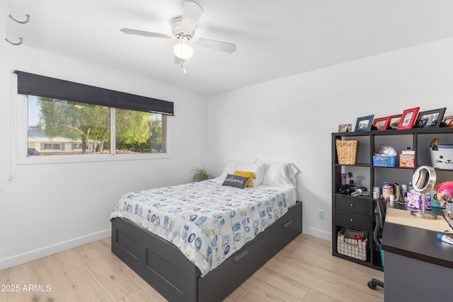 bedroom featuring a ceiling fan, baseboards, and light wood-style flooring