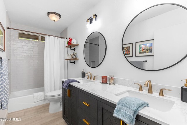 bathroom featuring a sink, shower / bath combo, toilet, and wood finished floors