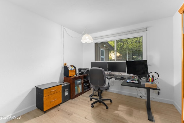 office space featuring baseboards and light wood-style flooring